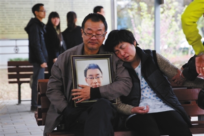 4月13日，陕西咸阳，魏则西的遗体被推去火化，父母坐在殡仪馆外等候。魏则西父亲说：“以后只有我们两个相依为命了。”
