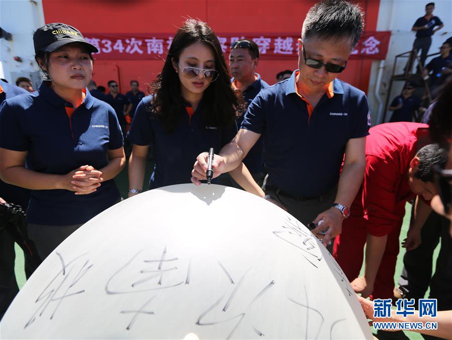 11月15日，在“穿越赤道纪念仪式”上，中国第34次南极科考队队员在即将放飞的气球上写下美好的祝愿。