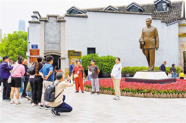 10月3日,渝中区曾家岩50号周公馆门前,众多市民游客与周恩来铜像合影留念。记者 李雨恒 摄/视觉重庆