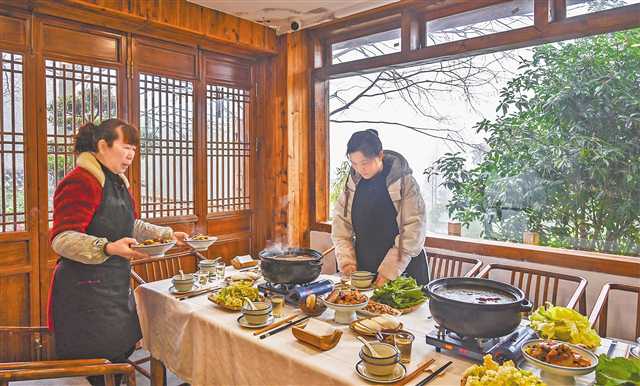 一月十五日，缙云村，“山之语”民宿老板周红（右）正在为客人准备美食。