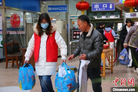 资料图为2025年春运期间，青年志愿者在青海省西宁市的客运站帮助旅客提取行李。　青海省交通运输厅供图
