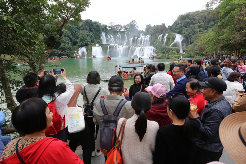 在德天跨国瀑布面前，岸线观景游人如织。梁婷摄
