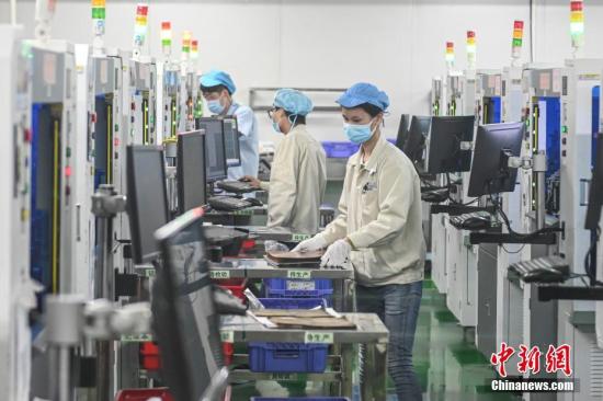 资料图：2月20日，位于广州南沙区的安捷利(番禺)电子实业有限公司内，复工人员戴着口罩在生产车间有序工作。<a target='_blank' href='http://www.chinanews.com/'>中新社</a>记者 陈骥旻 摄