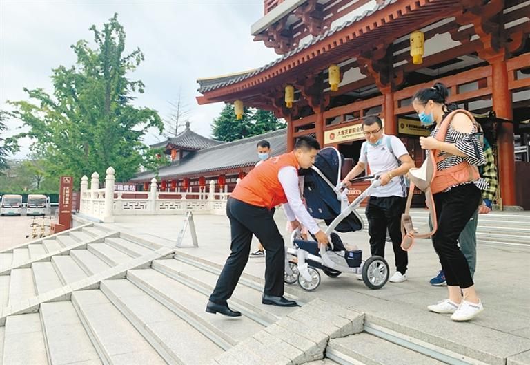 志愿者在大唐芙蓉园门口为游客提供帮助。(资料图片)