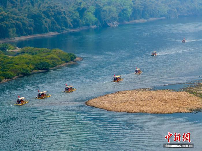 广西桂林漓江阳朔县兴坪古镇段，青峰倒映在澄澈的江面，游客泛舟碧波之上，感受喀斯特山水的灵动秀美（资料图）。何华文 摄